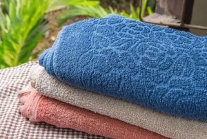 3 towels stacked on each other on a chaise lounge. You can see the different colors, and textures in this image. 