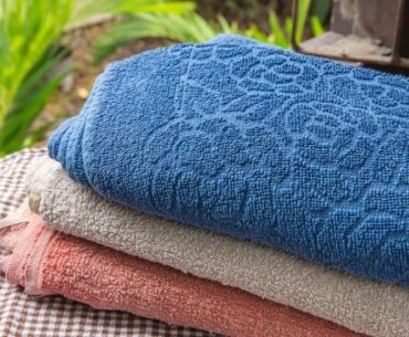 3 towels stacked on each other on a chaise lounge. You can see the different colors, and textures in this image.
