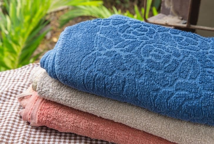 3 towels stacked on each other on a chaise lounge. You can see the different colors, and textures in this image.